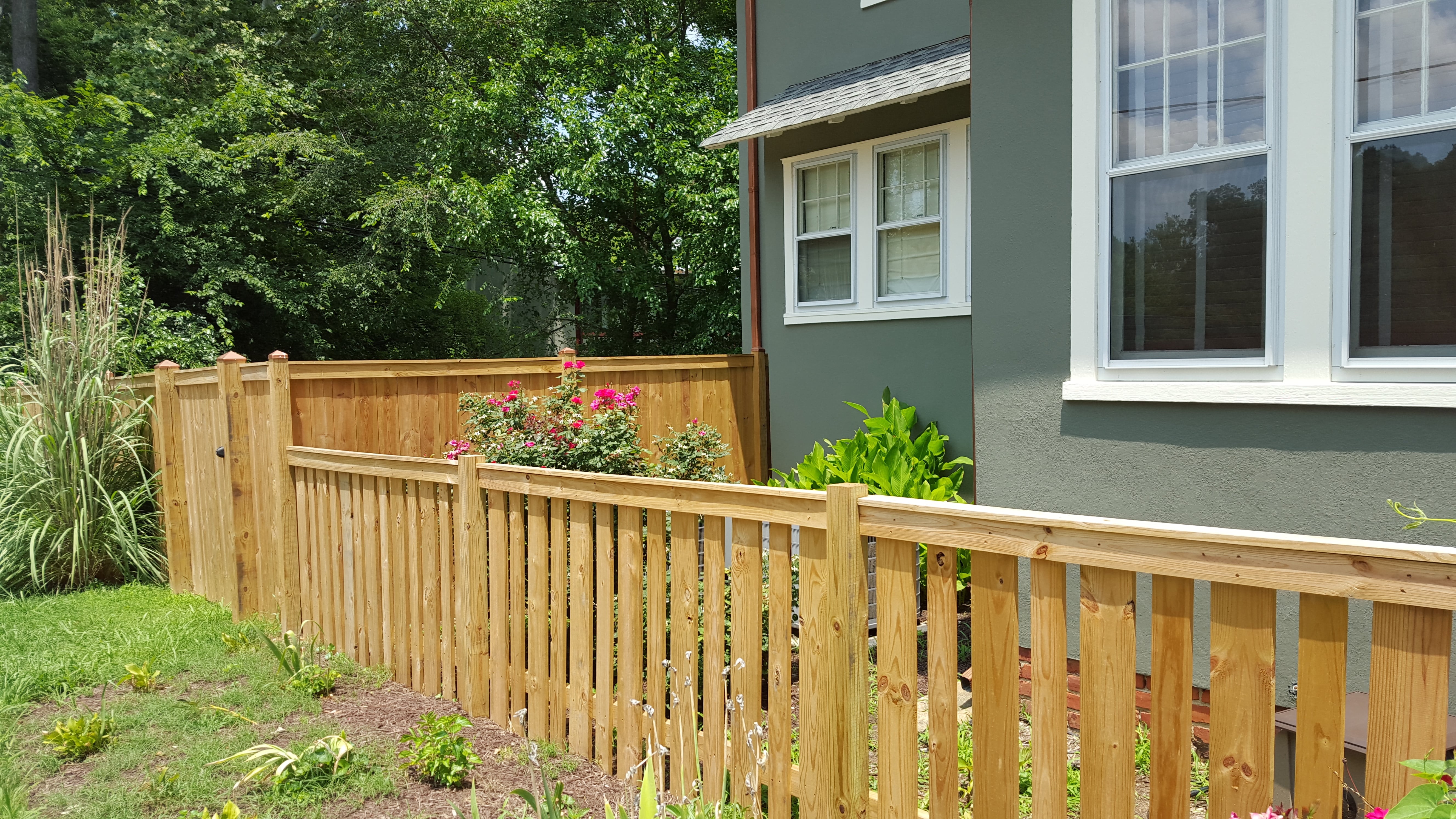 A custom alternating wood picket fence designed by the owner in Richmond, Virginia