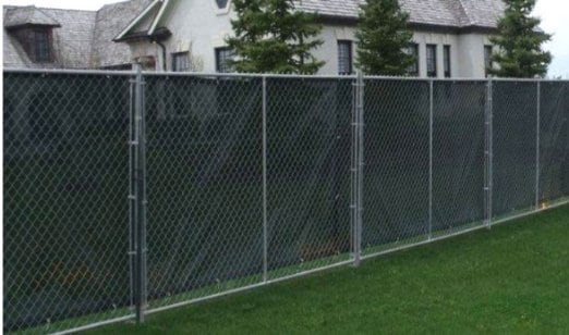 Black windscreen covers a temporary fence enclosure ouside of a suburban neighborhood