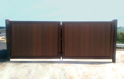 A brown wood grain Composite Dumpster Gate  has one latch down the center for easy and frequent access.