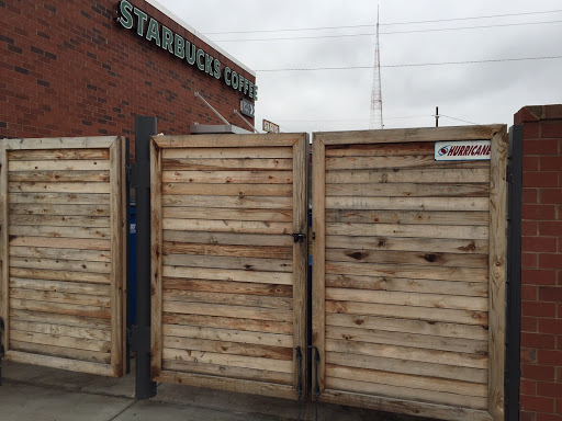 A beautiful wood stained, brick and steel gate dumpster enclosure  outside of starbucks in Richmond Virginia 